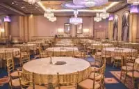 Inspiration: grand indoor banquet hall with round tables, chandeliers and a decorated wedding stage