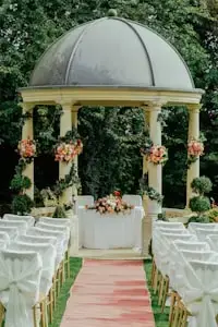 Inspiration: garden wedding ceremony pavilion with floral columns and white aisle chairs